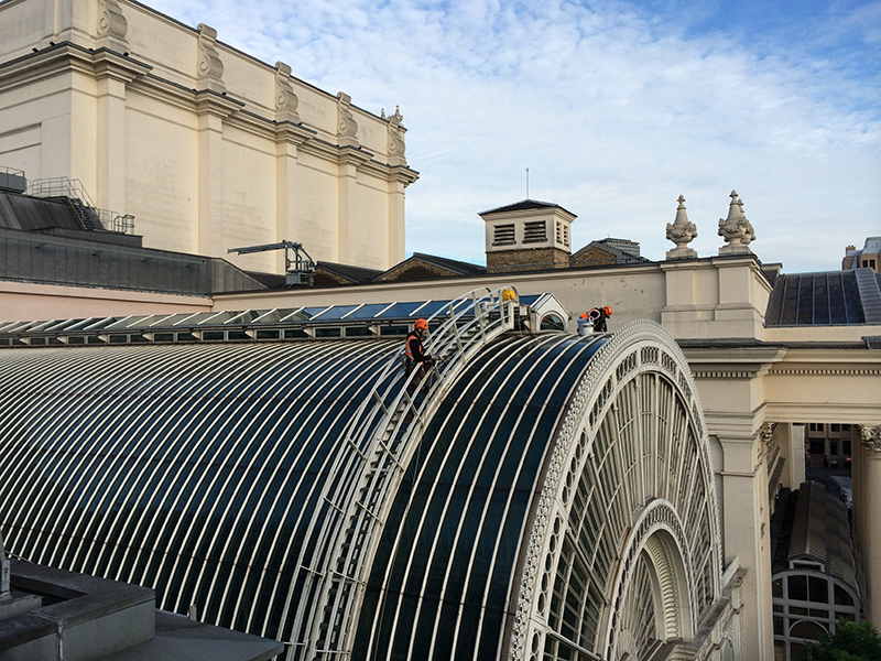 Rope access technicians carrying out high-level atrium glazing inspection and leak repair on a curved glass roof
